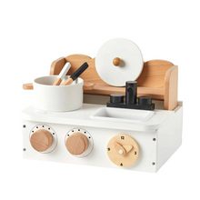 A wooden kitchen stove playset with a white stove top, wooden pot, spoon, and fork, and a plastic sink. The set features a clock and turntable knobs.