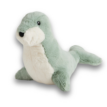 A sage green plush toy resembling a seal with a white stomach