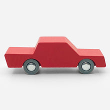 Simple red wooden car with grey wheels on a white background
