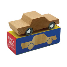 A wooden toy car with a neutral color placed on a box with the text 'BACK & FORTH' printed on it.