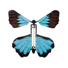 A wind-up butterfly-shaped decorative object with two dark brown wings tipped in bright turquoise blue, attached to a black and white central body, shown on a plain white background.