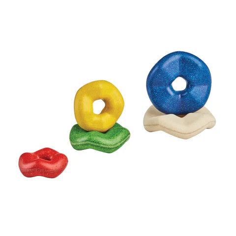 Blue, red, green, white and yellow donut like wooden rings in various sizes.