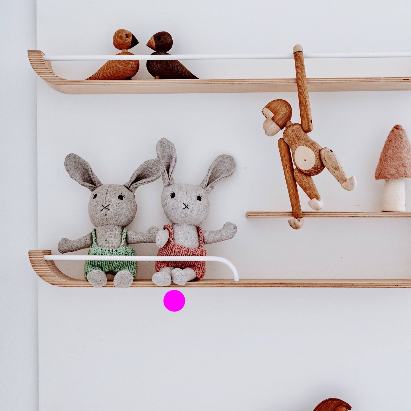 Wooden shelves with stuffed animals on a white wall