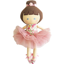 A baby ballerina doll with a fluffy pink tulle tutu and a floral bodice. The doll has a embroidered face, brown hair with a ballet style top knot, and is wearing pink ballet shoes.
