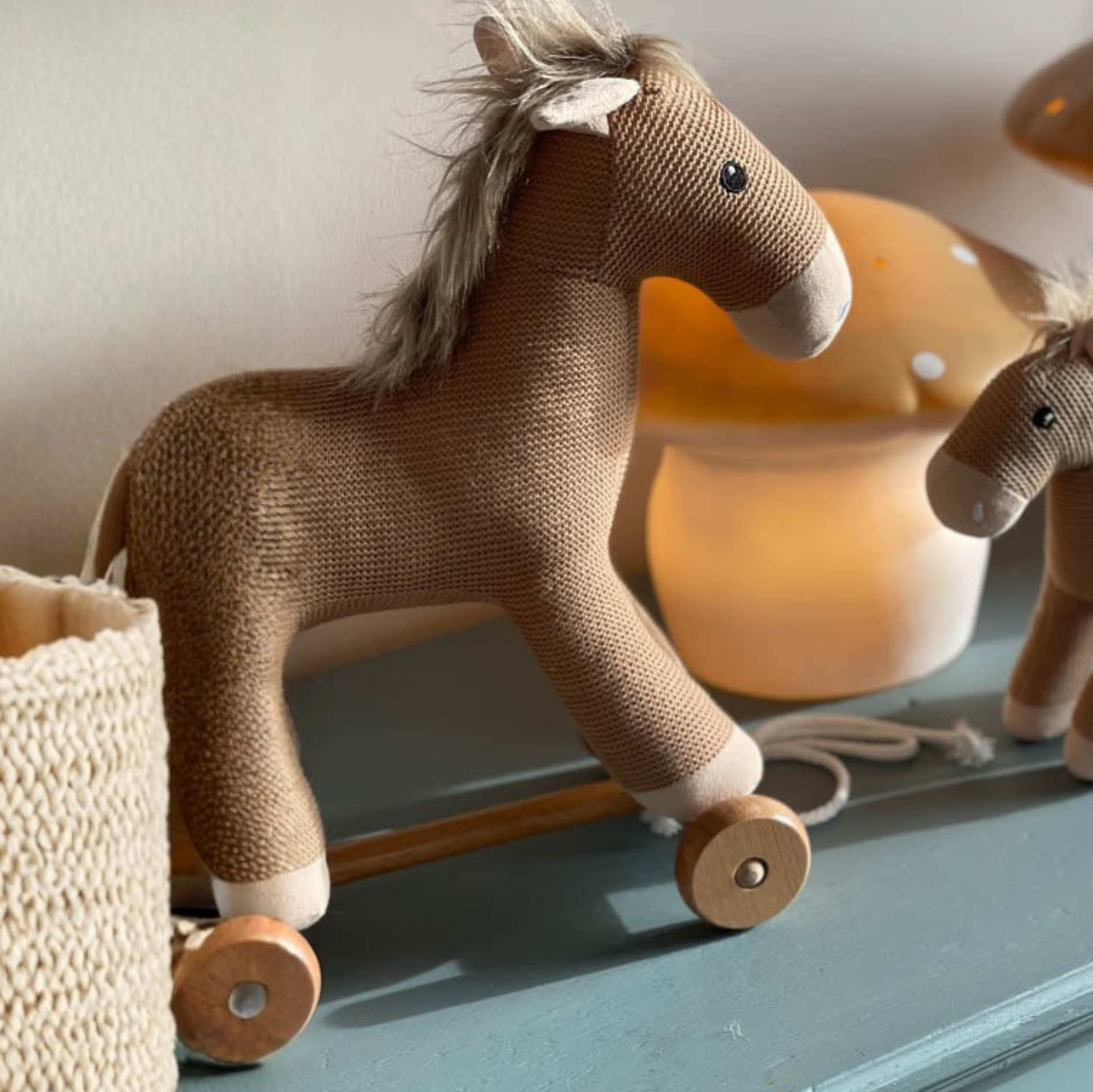 Two plush toy horses on a surface with soft lighting