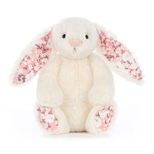 A plush toy resembling a bunny with a soft white body and pink floral patterns on the ears and feet.