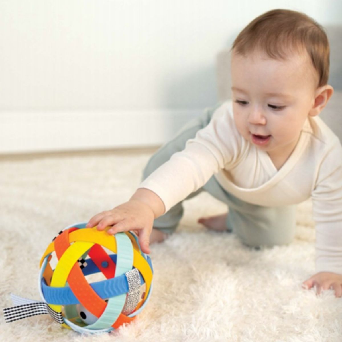 Baby reaching for the Manhattan Toy Blissful Ball during play