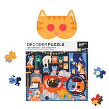 A colorful children's decoder puzzle featuring cartoon cats in various playful poses and a cat-themed room with a variety of decorations. The puzzle is unassembled with several pieces spread out, and two decoder masks are included in the image.