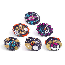 Decorated space-themed discs from the Djeco Hypno Cosmos Spinning Tops Craft Kit