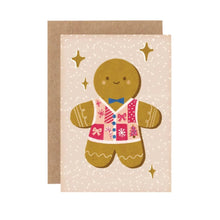 A mini greeting card featuring an illustrated gingerbread person with a pink and blue Christmas sweater, accompanied by a brown envelope.