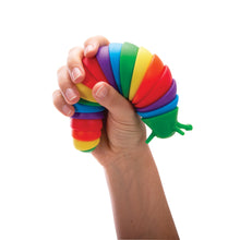 A hand holding a colorful, articulated sensory toy shaped like a slug.