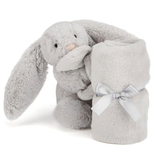 A plush silver bunny toy with a satin ribbon attached, designed as a soother for babies.