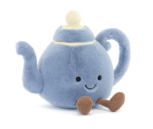A plush toy resembling a blue teapot with a cream-colored lid and brown corduroy legs, featuring a friendly facial expression.