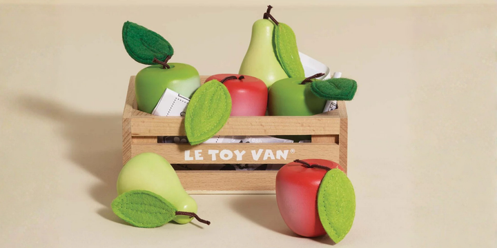 Wooden crate with toy apples and pears on a beige background, featuring 'LE TOY VAN' branding.
