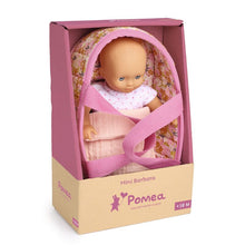 Pompea Mini Barbara doll in a floral basket with pink straps inside a packaging box.