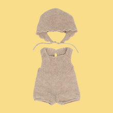 A beige knitted romper and bonnet set for 38cm dolls, displayed against a yellow background.