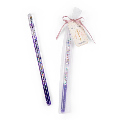 Giltter magic wand toy with a clear tulle bag and ribbon on a white background