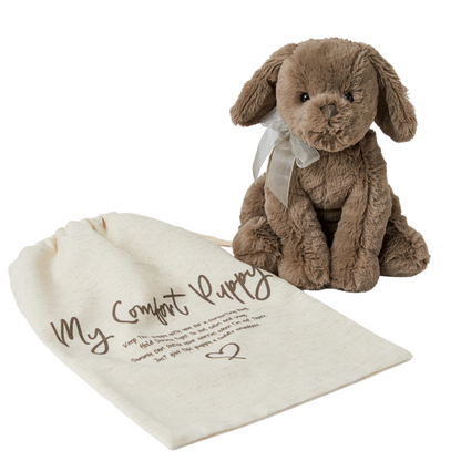 Chocolate brown dog soft toy with bow around the neck and cloth storage bag, against a white backgroound.