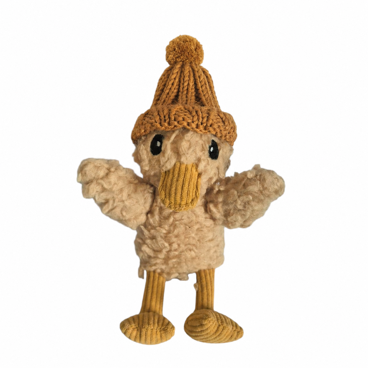 A plush toy duck dressed in a cozy knit winter outfit, featuring a tan textured body, yellow beak, yellow striped legs, and a brown knit hat with a pom-pom, set against a plain white background.