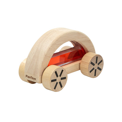 Natural wood car shaped toy with large wooden wheels, filled with light red water suspended behind clear plastic windows 