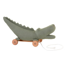 A green knitted crocodile pull-along toy with a solid beech-wood base and wheels.