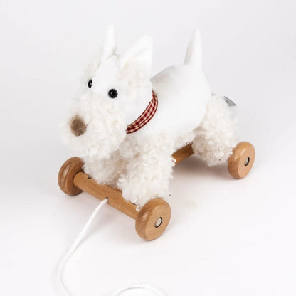 White plush dog toy with wooden wheels on a white background