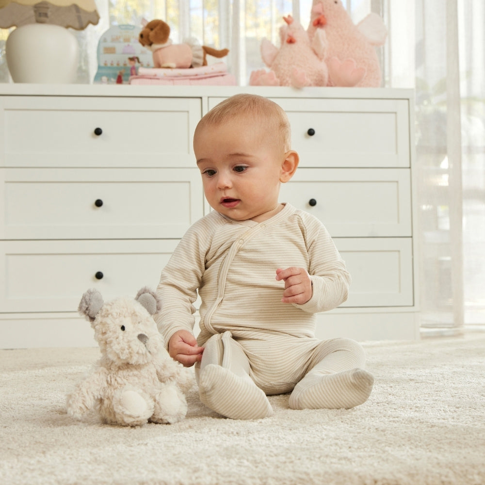 Baby in a white room with toys and furniture