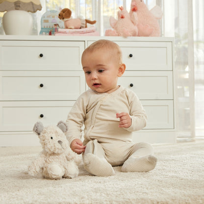 Baby in a white room with toys and furniture