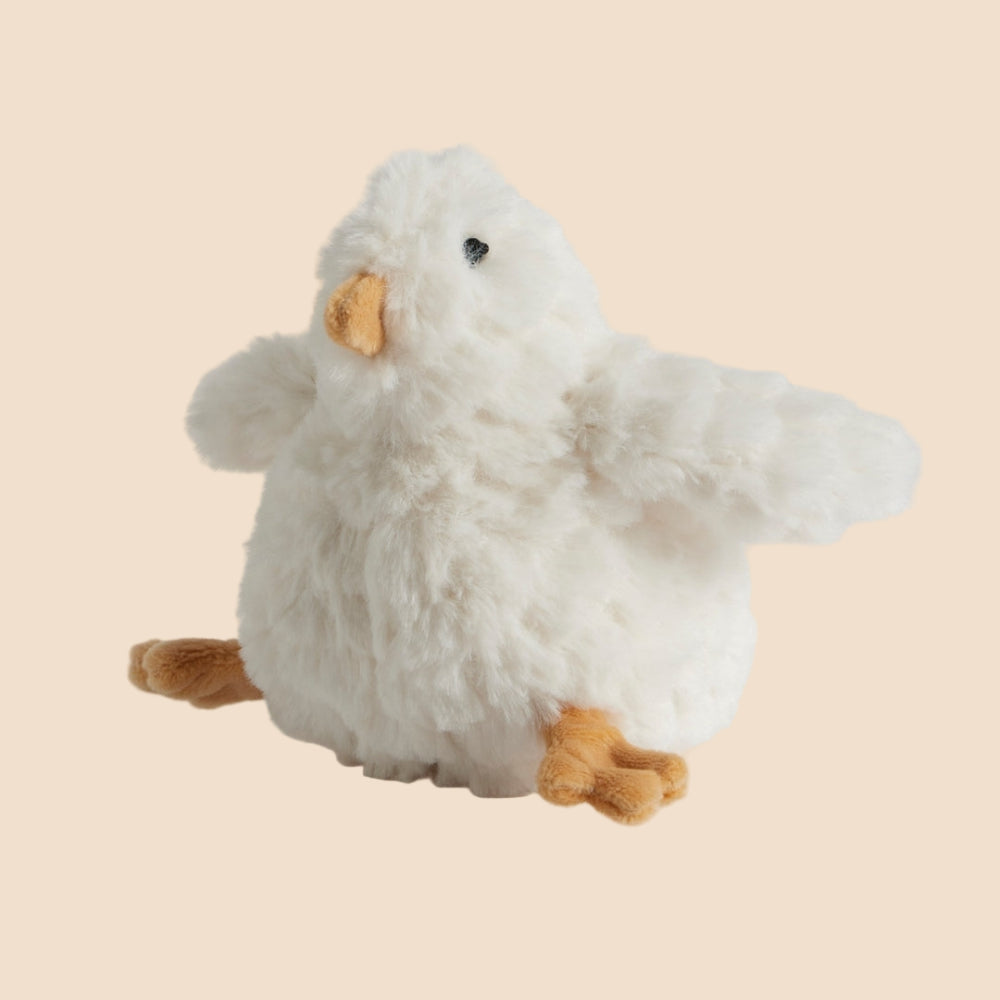 Small Plush toy chicken baby rattle on a cream background