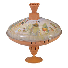 A vintage metal spinning top with animal illustrations on the top surface, painted in a beige and brown color scheme.