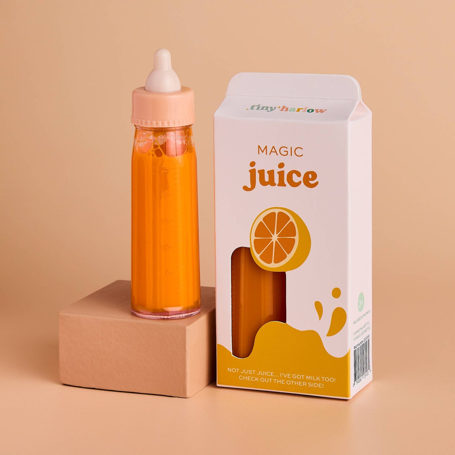 Orange juice bottle with a box labeled 'Magic Juice' on a beige background