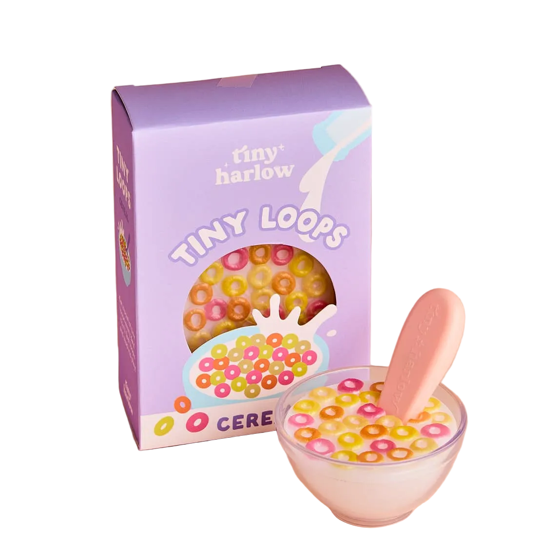 Bowl of dolls pretend colorful cereal with a spoon next to a Tiny Harlow cereal box on a white background
