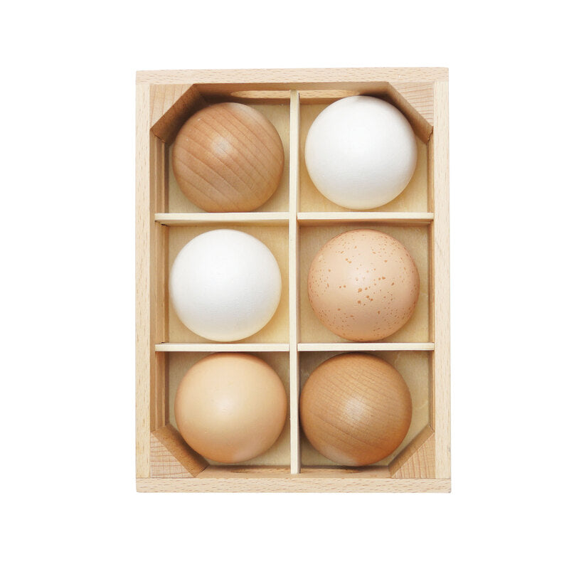 Set of wooden and eggs in a wooden box on a white background