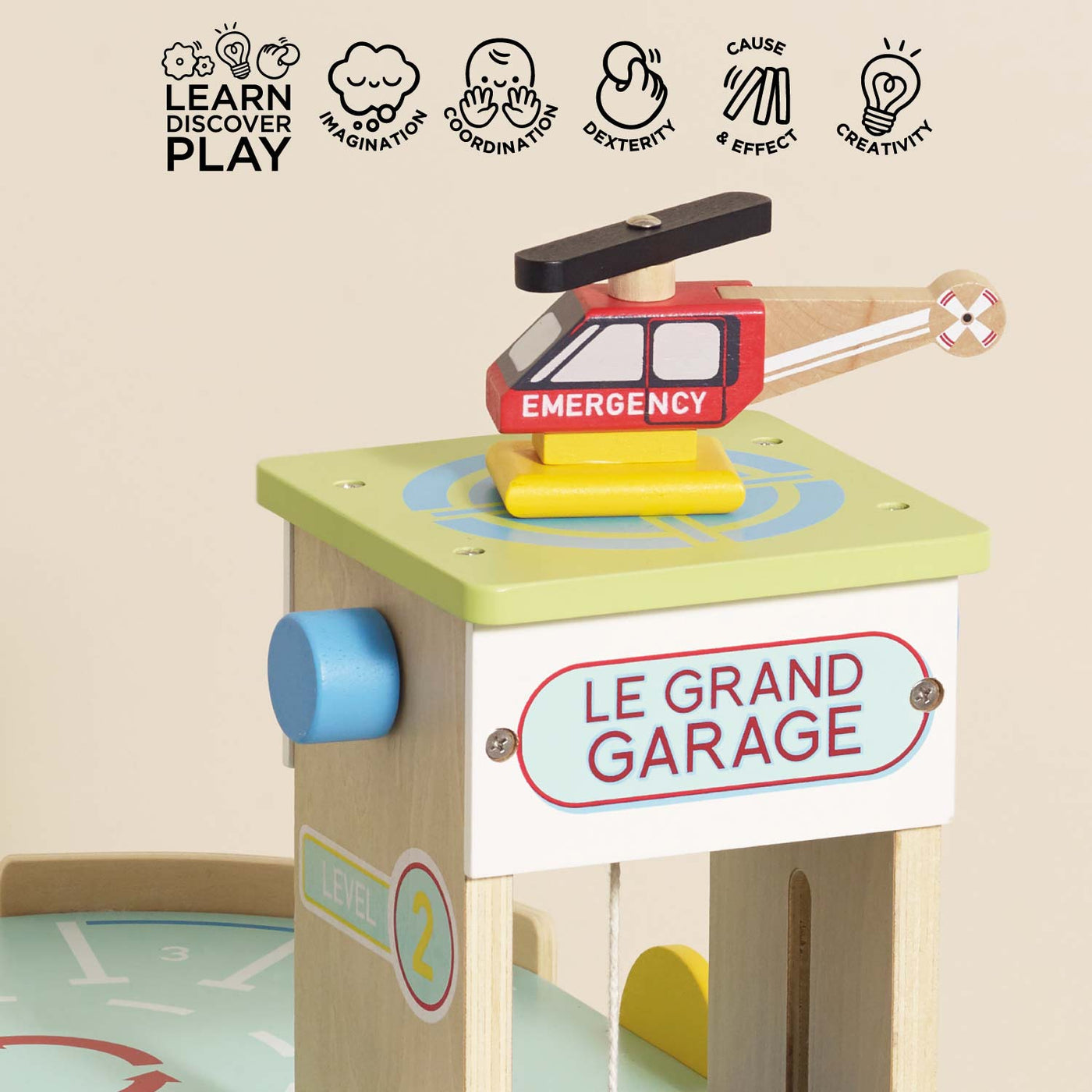 Wooden toy garage with helicopter on top, featuring educational icons and text.