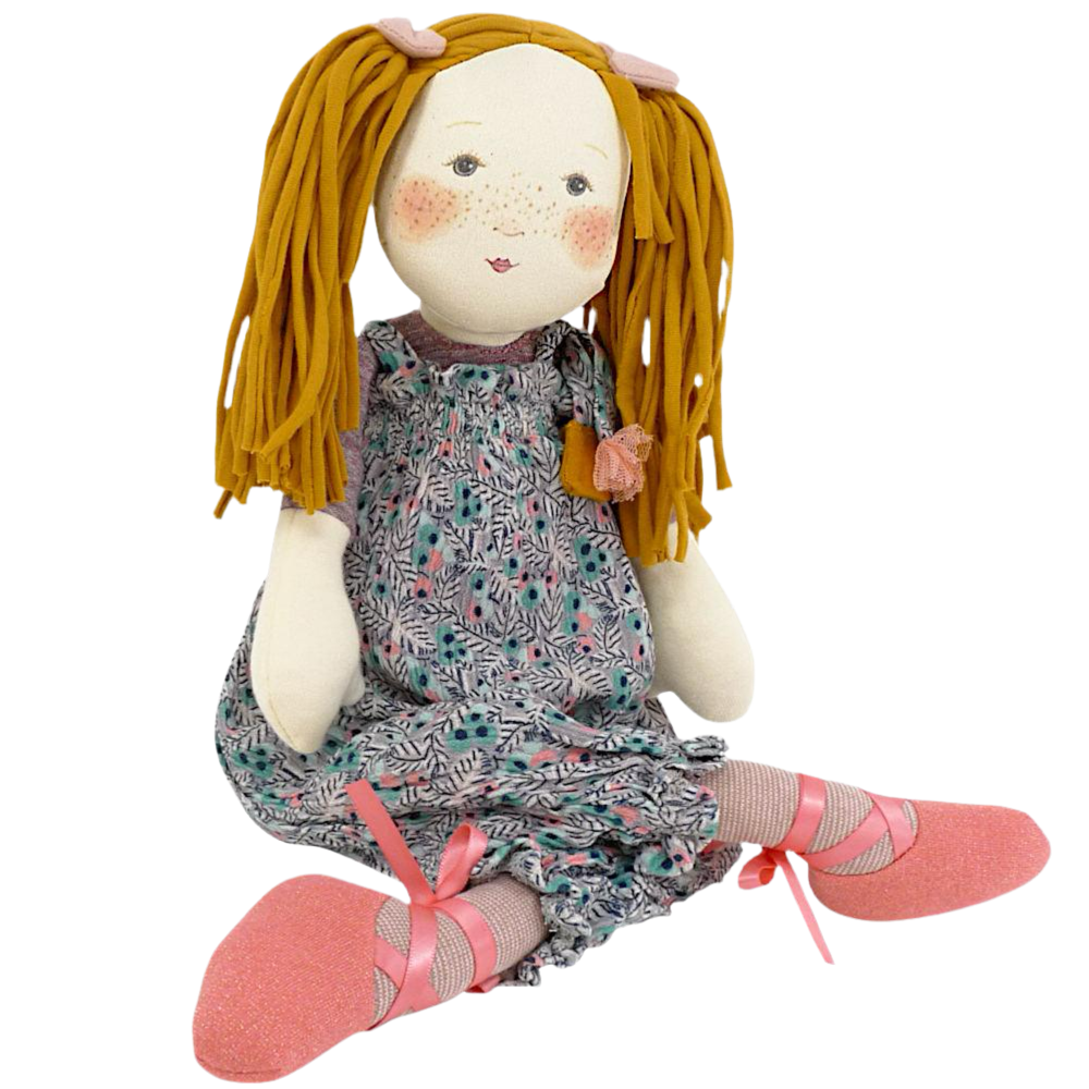 Rag doll with blonde pigtails and floral bloomers on a plain background