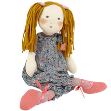 Rag doll with blonde pigtails and floral bloomers on a plain background