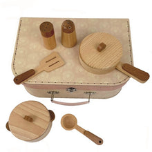 A wooden cooking set in a cardboard case, including a stock pot with lid, frying pan with lid, salt and pepper shakers, spatula, and soup ladle, all made from beech wood.