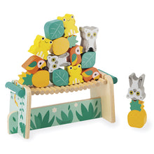 A wooden balancing game featuring colorful animal figures such as frogs, lemurs, and parrots on top of a bridge with leaf accents.