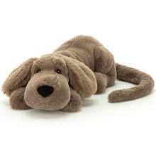 A brown dog soft toy with black nose, pictured lying flat on a white background.