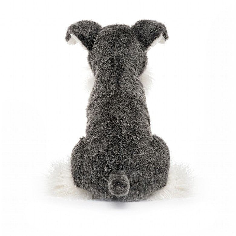 A dark grey and white soft toy resembling a dog