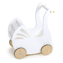 A white doll pram designed in the shape of a swan, with a fabric canopy and natural wood wheels. The pram is empty and appears to be intended for pretend play.