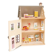 Open wooden dolls house with various wooden doll house furniture pieces on display