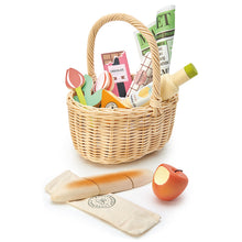 Various wooden play food items with a natural wicker basket on a white background