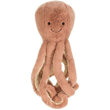 A large brick coloured soft toy with smiling face, resembling an octopus.