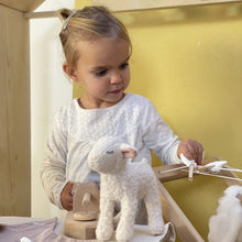 Young girl playing with wooden clothes line and May Lamb soft toy - Egmont Toys