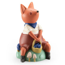 A resin money box figurine of a squirrel wearing a shirt and holding a basket with berries, seated on a round base that features mushrooms.