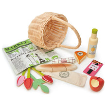Various wooden play food items with a natural wicker basket on a white background